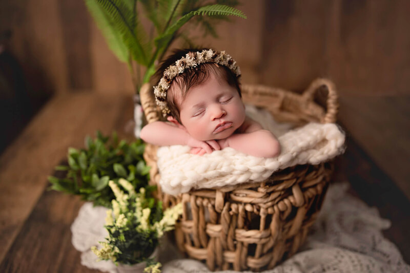 baby posed with head on hands in boho basket during  photoshoot with Hamilton Newborn Photographer, White Orchid Photography