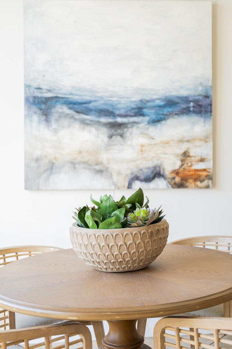 breakfast table with green plant and blue art in background
