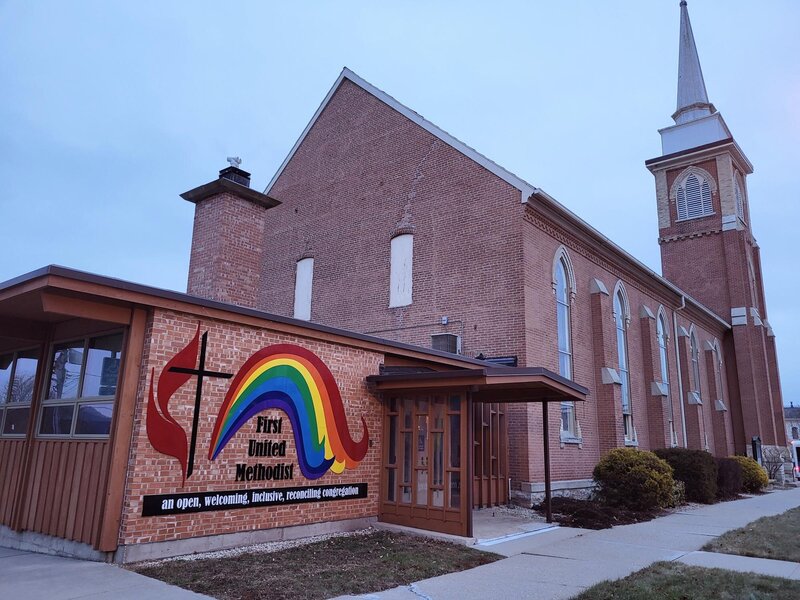 Exterior of First United Methodist Church in Decorah, Iowa, showing the rainbow mural and clinic location entrance.