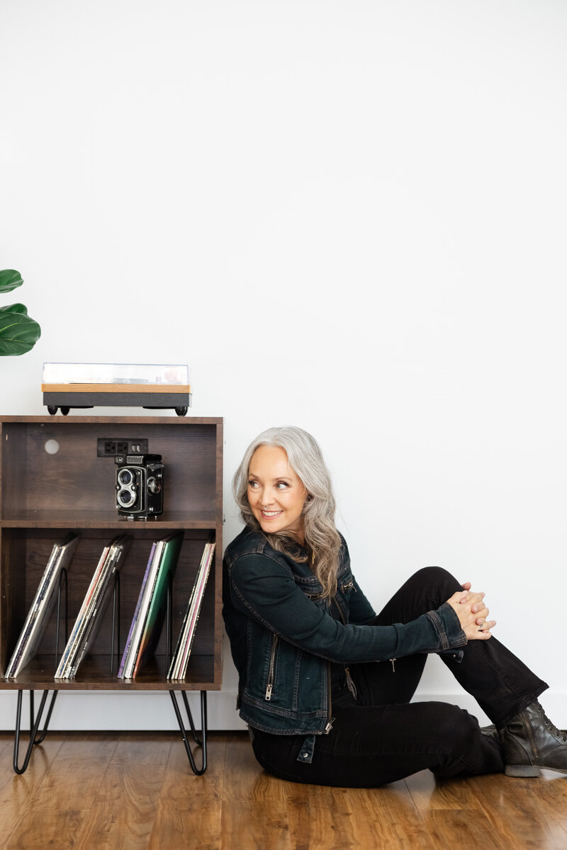 Bay Area brand photographer sitting on the ground next to her record player and old yashika twin lens camera
