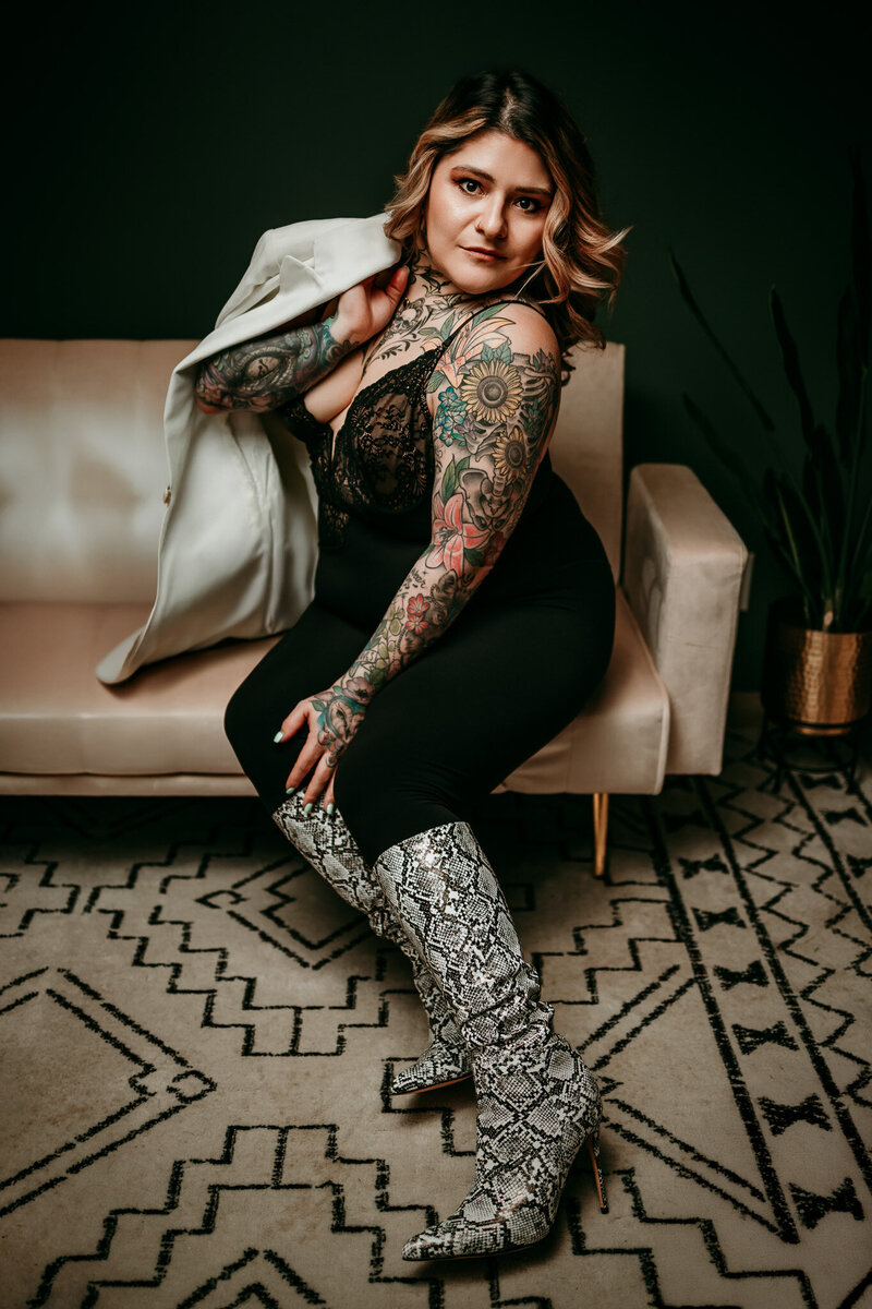 woman sitting on white couch wearing black fur coat and white boots