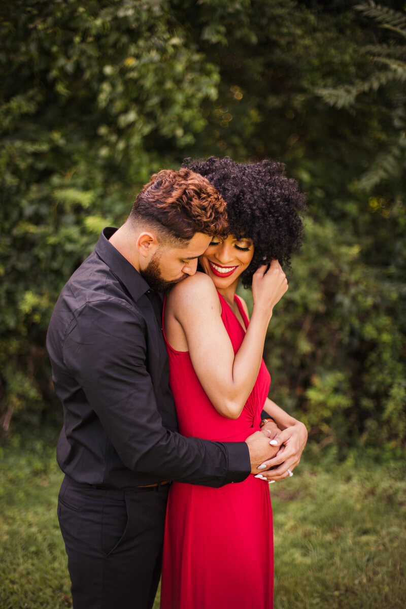 engaged couple hugging while man kisses woman's shoulder during gatlinburg engagement session