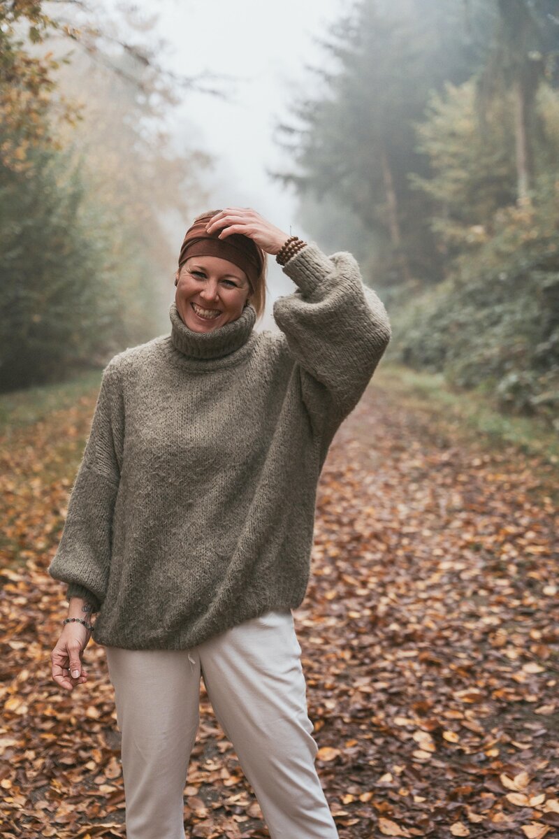 Isabell steht lachen im herbstlichen Wald