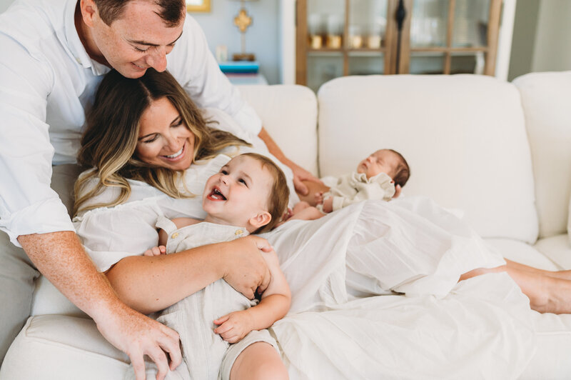parents playing with toddler and newborn