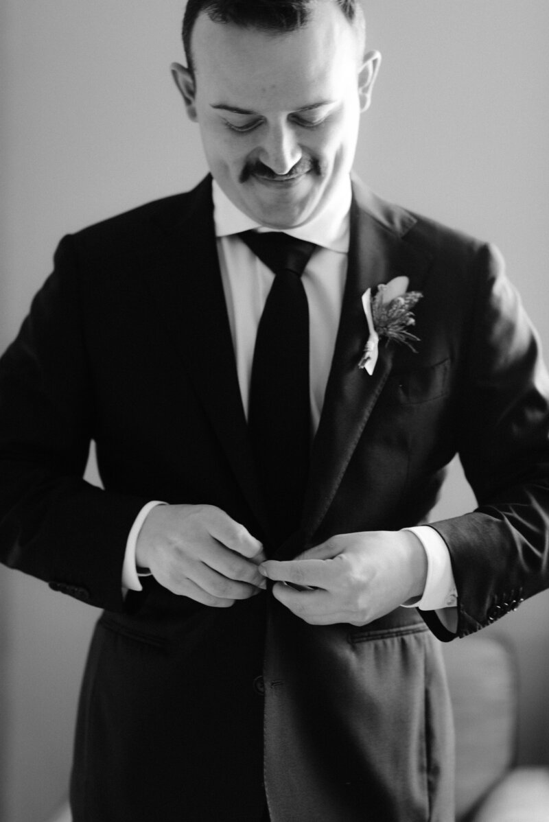 groom buttons up suit