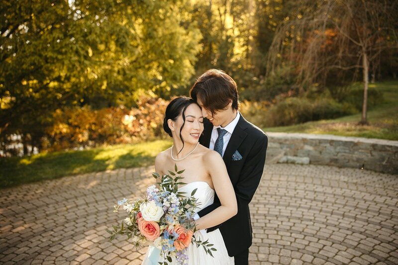Groom embracing bride during romantic outdoor portrait