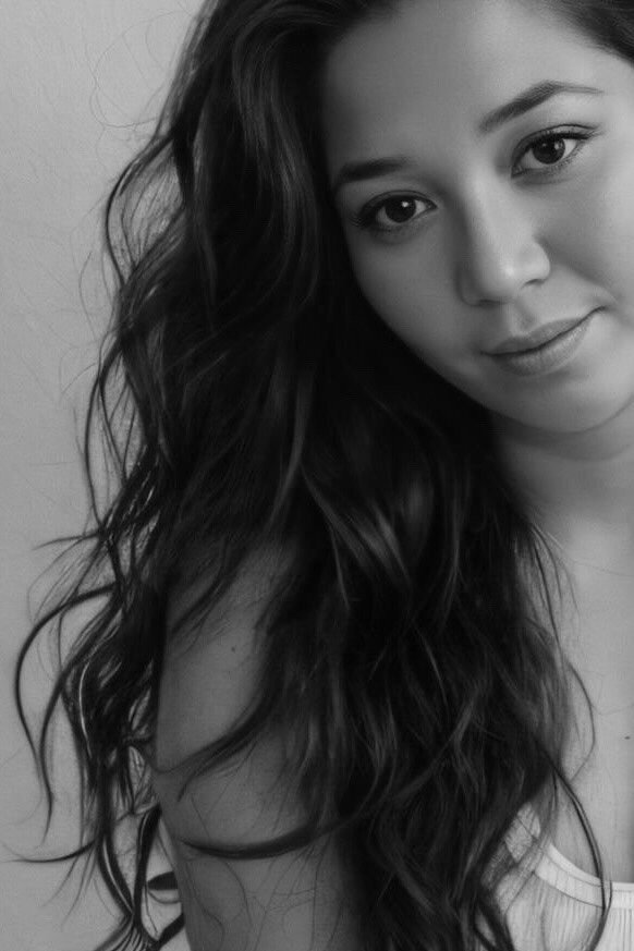 Black and white portrait of Jenni, founder of Jenuinely Aligned, smiling confidently with long wavy hair — representing soulful and empowered business coaching for women