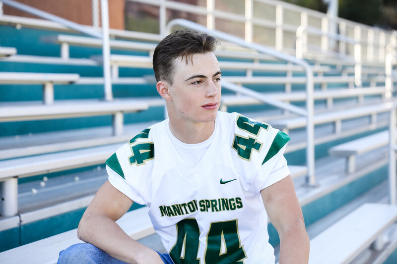 Sports senior picture of a football player sitting in the stands