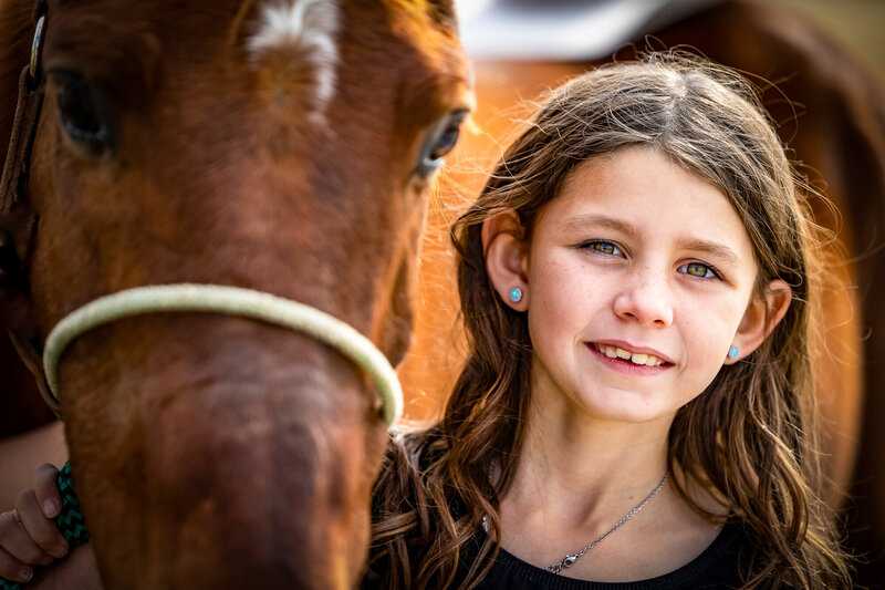 Young girls face with horse looking at camera