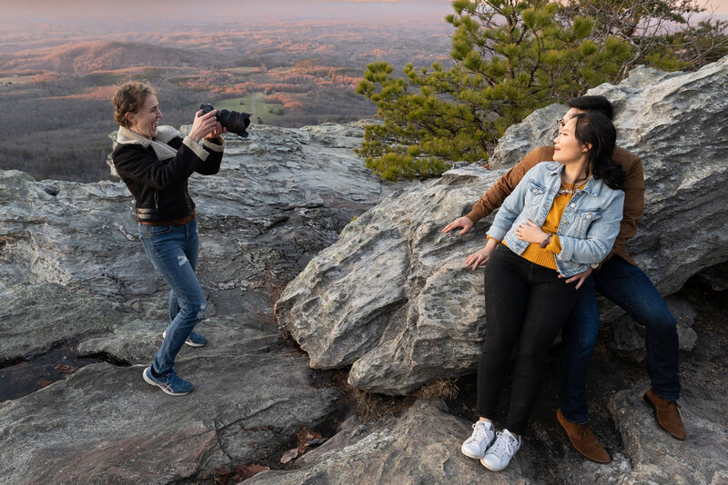 Top raleigh wedding photographer taking photo of couple on mountain side at hanging rock state park