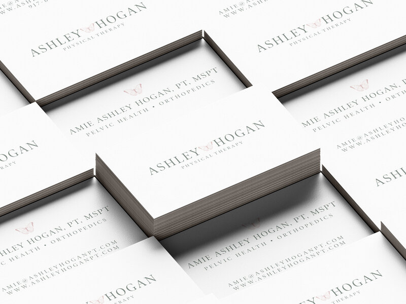 Stacks of Ashley Hogan Physical Therapy business card featuring logo on front with information on the back