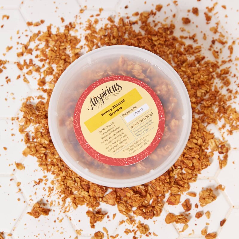 A colorful, custom designed label applied to a plastic takeout container filled with granola