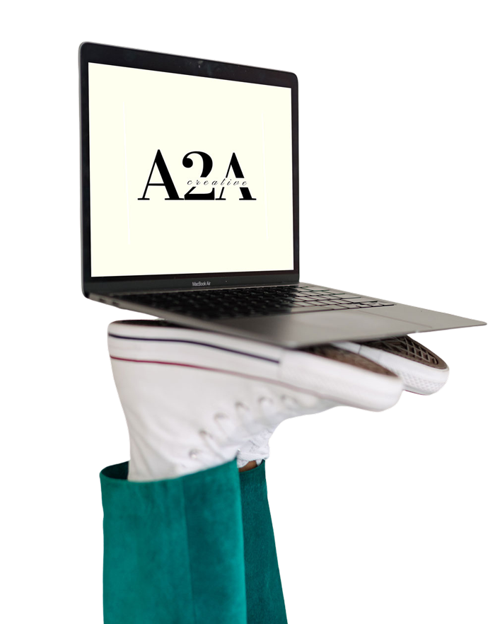 An open MacBook sits atop a peron's feet