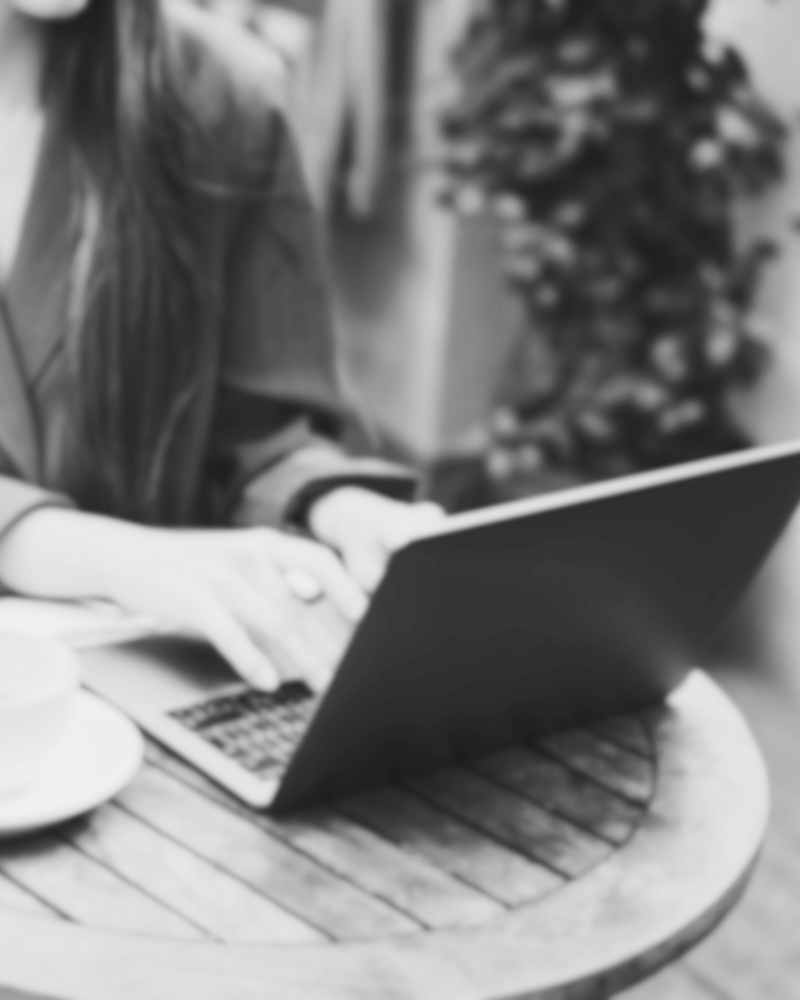 Stock image of a woman typing on a laptop, representing business growth, confidence, self-love, and Main Character Energy aligned with Letitia Hopkins' life, love, and relationship coaching work.