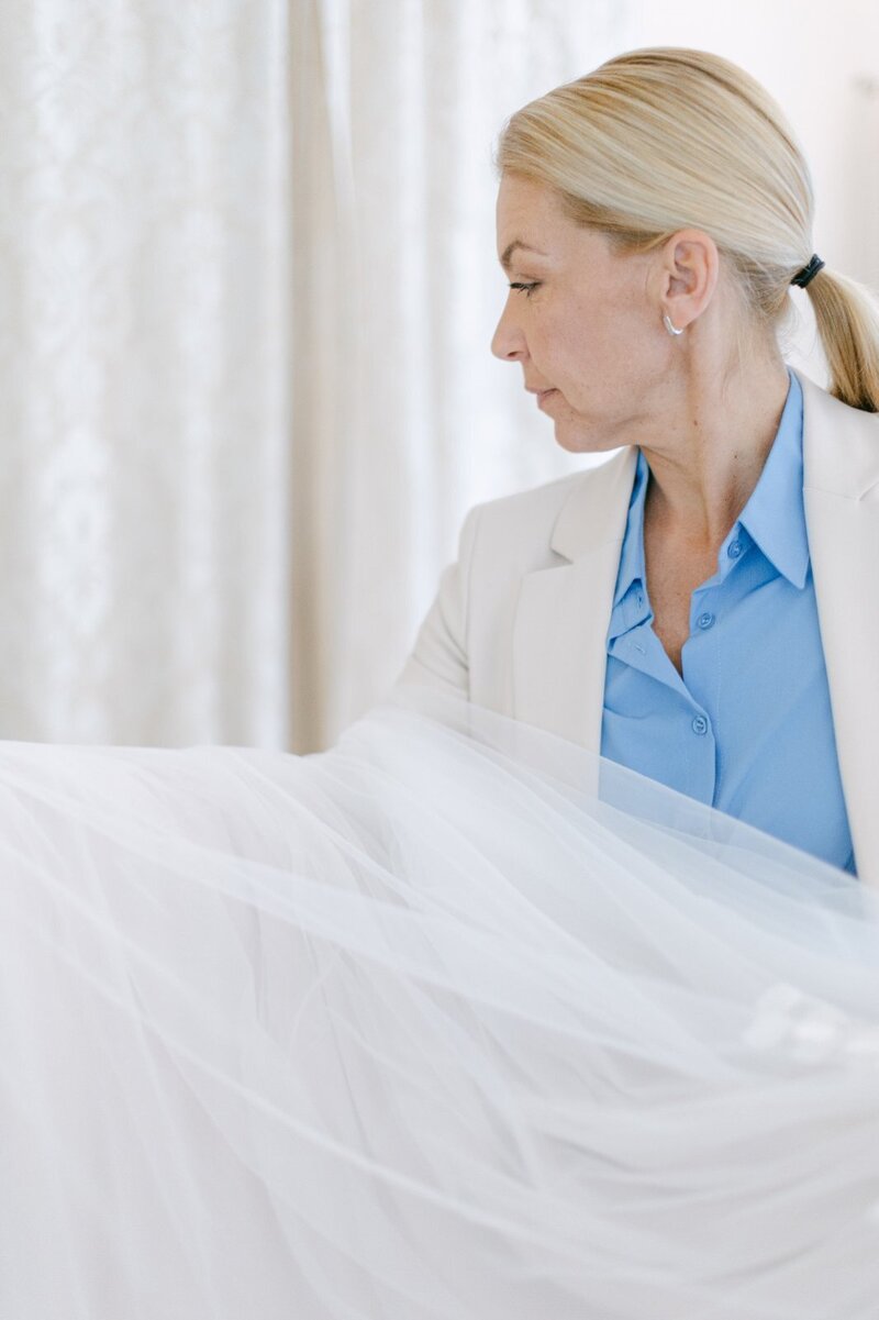 Team of luxury ECLAT Destination Weddings assisting with a haut couture gown 