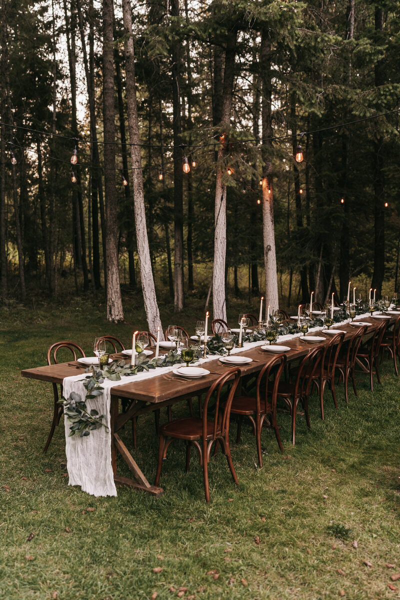 A beautiful tablescape for an intimate dinner in the woods with twinkle lights.