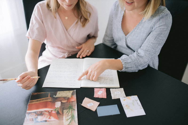 julia and val point to words on page in notebook niagara marketing company