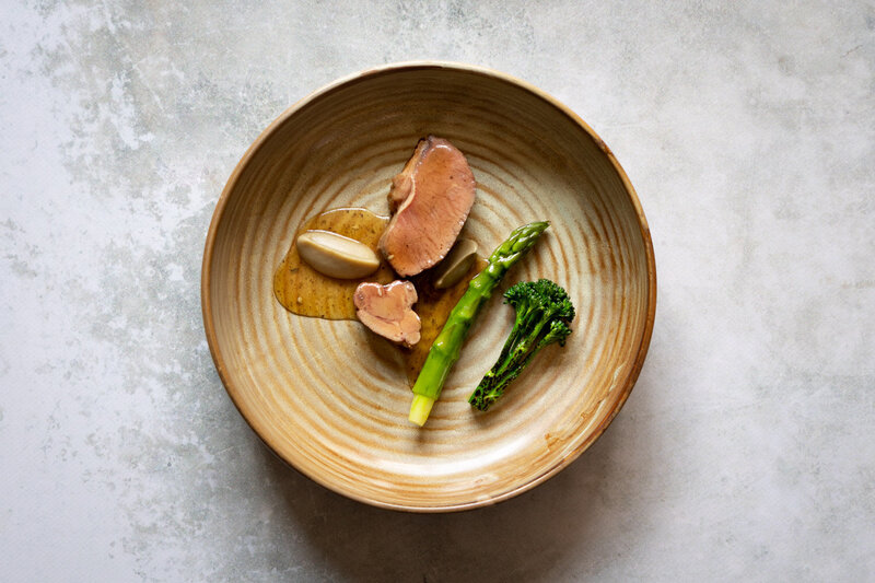 Lamsvlees, groene asperge, broccoli op een bruin bord. Culinaire fotografie door Dorien Paymans | Studio Ensō Groningen ©