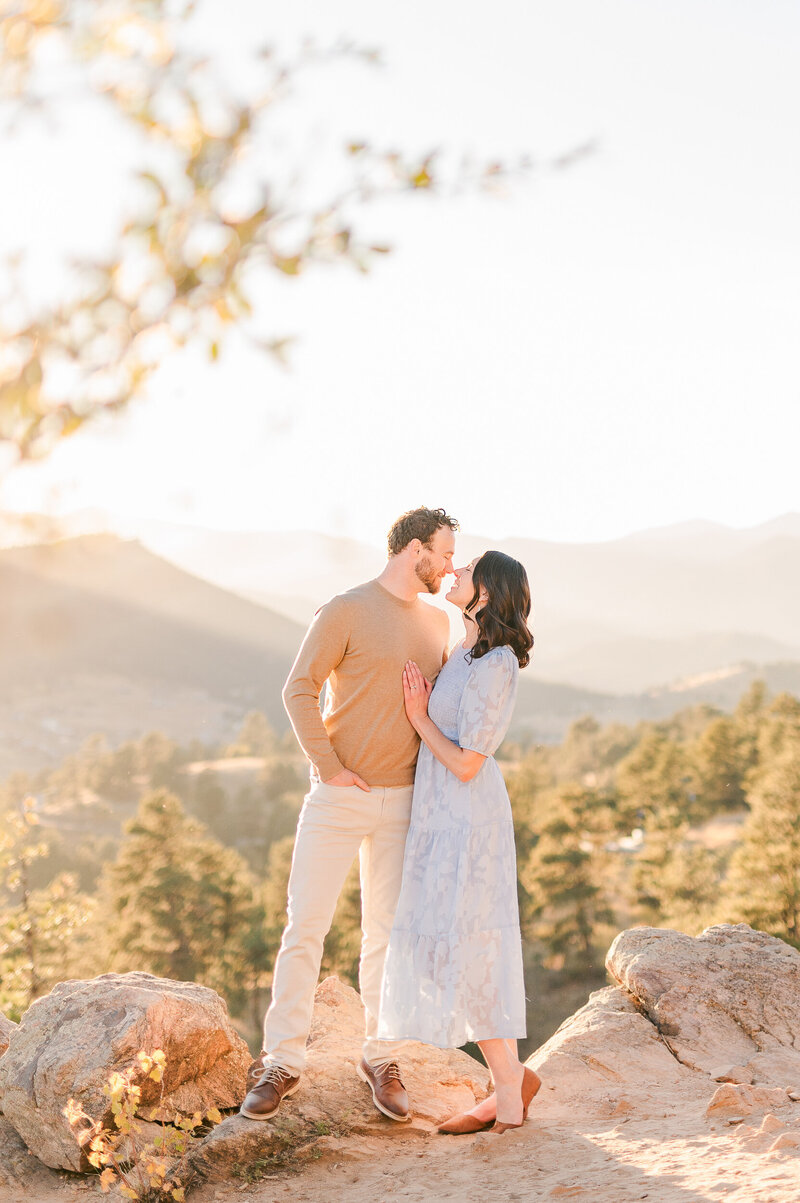 Sunset portrait of a couple looking at each other with the Colorado mountains in the background.