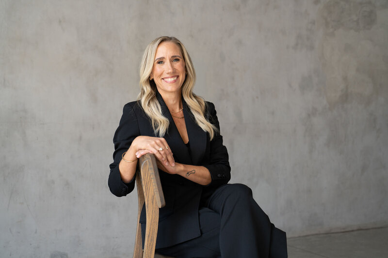 Nicole Woods sitting on a chair facing the camera and smiling