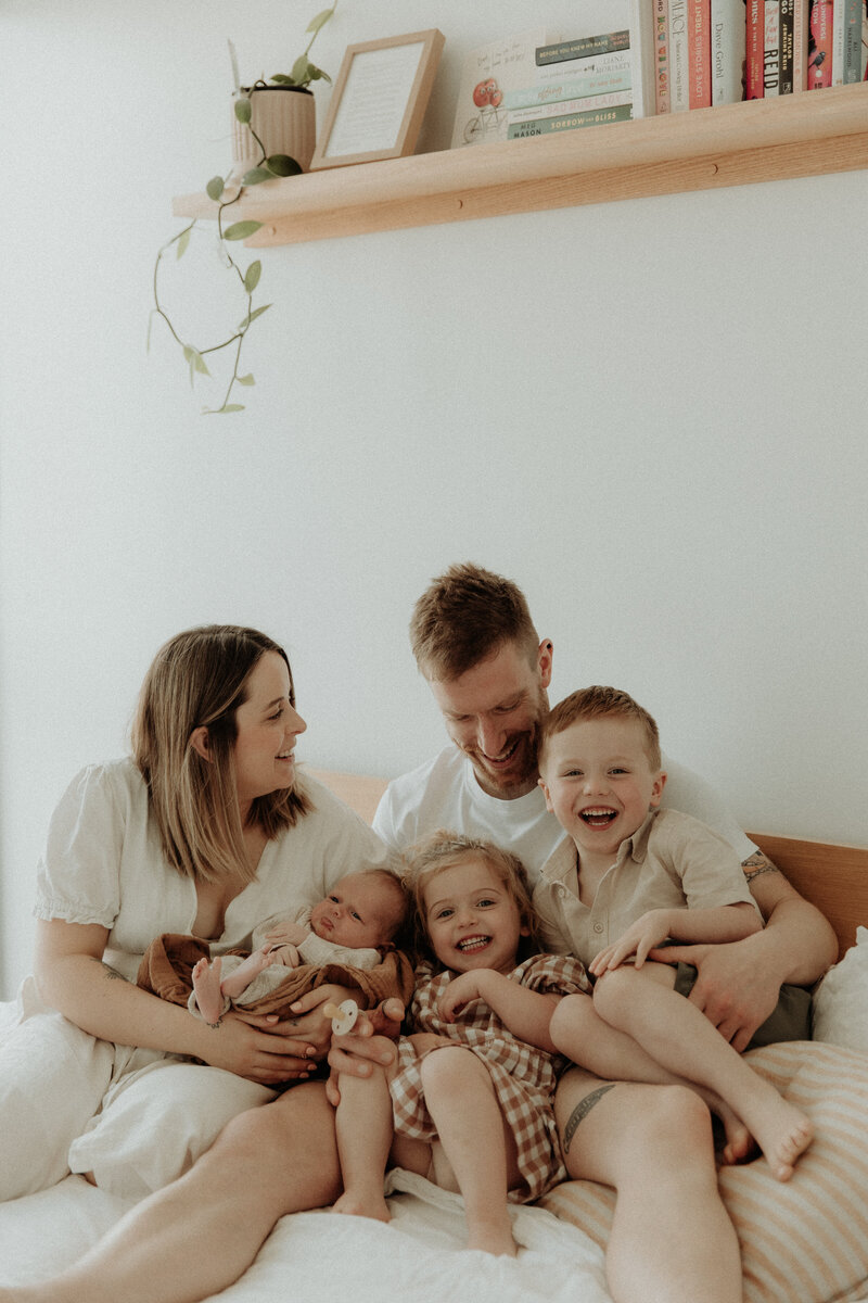 Mum holding newborn baby smiling
