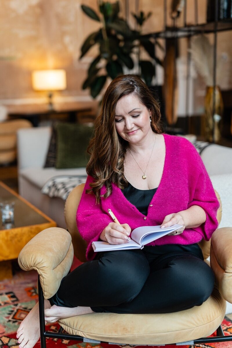 Bryony Williams in pink sweather sitting on a sofa