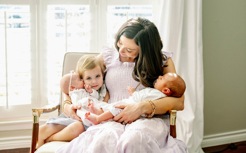 mom holding newborn twins and oldest daughter during in home session