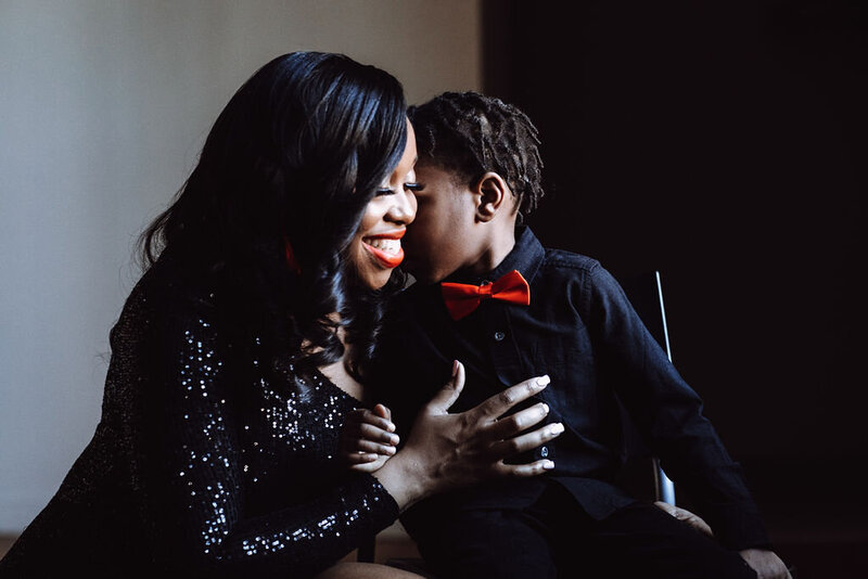 A mother and son dressed in formal attire embrace.