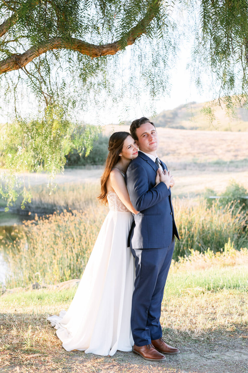Bride and groom stand forehead to forehead outdoors in Ojai