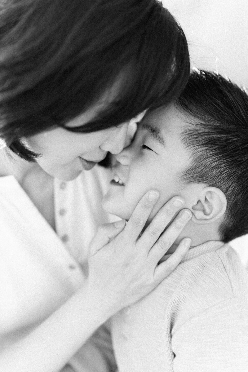 Black and white image of pregnant mother with hands on belly as photography by maternity photographer Sarah Vassallo