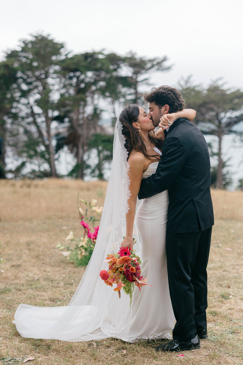 Wedding Photographer Services in the Bay Area, bride and groom kissing with tall trees in the background