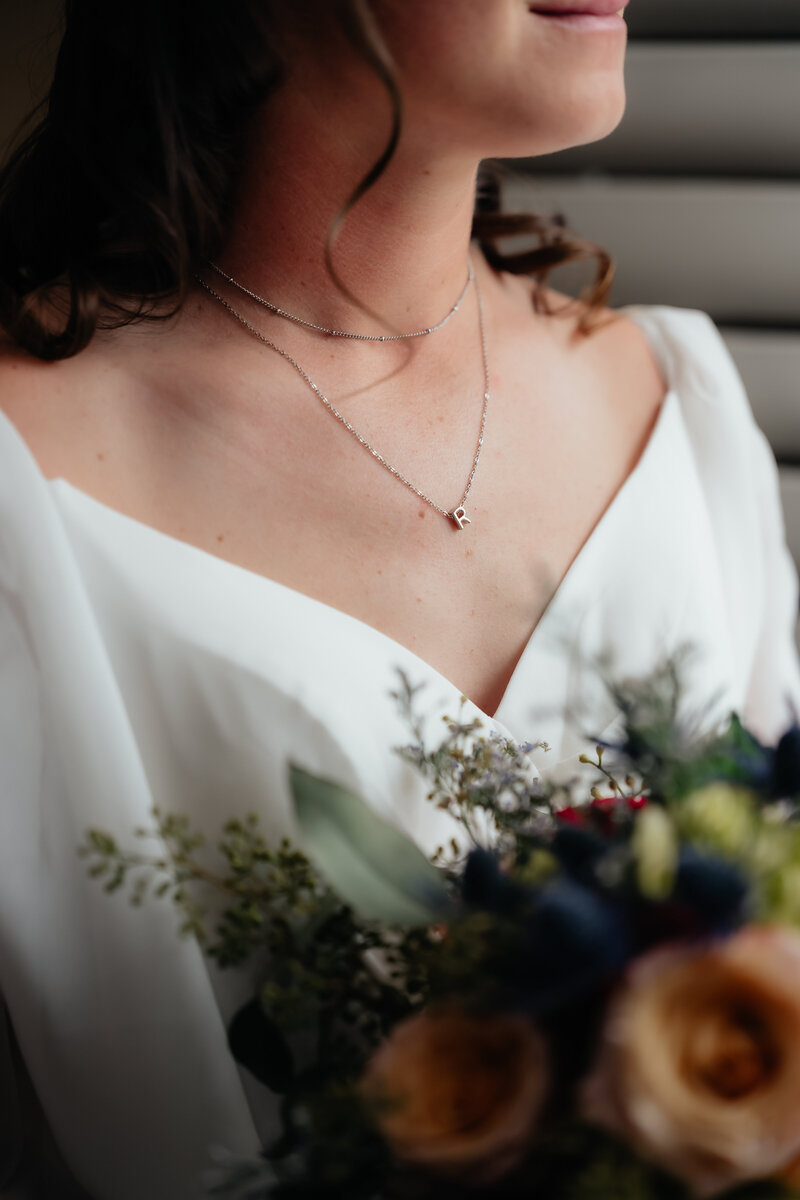 bride gently smiling while holding her bridal bouquet