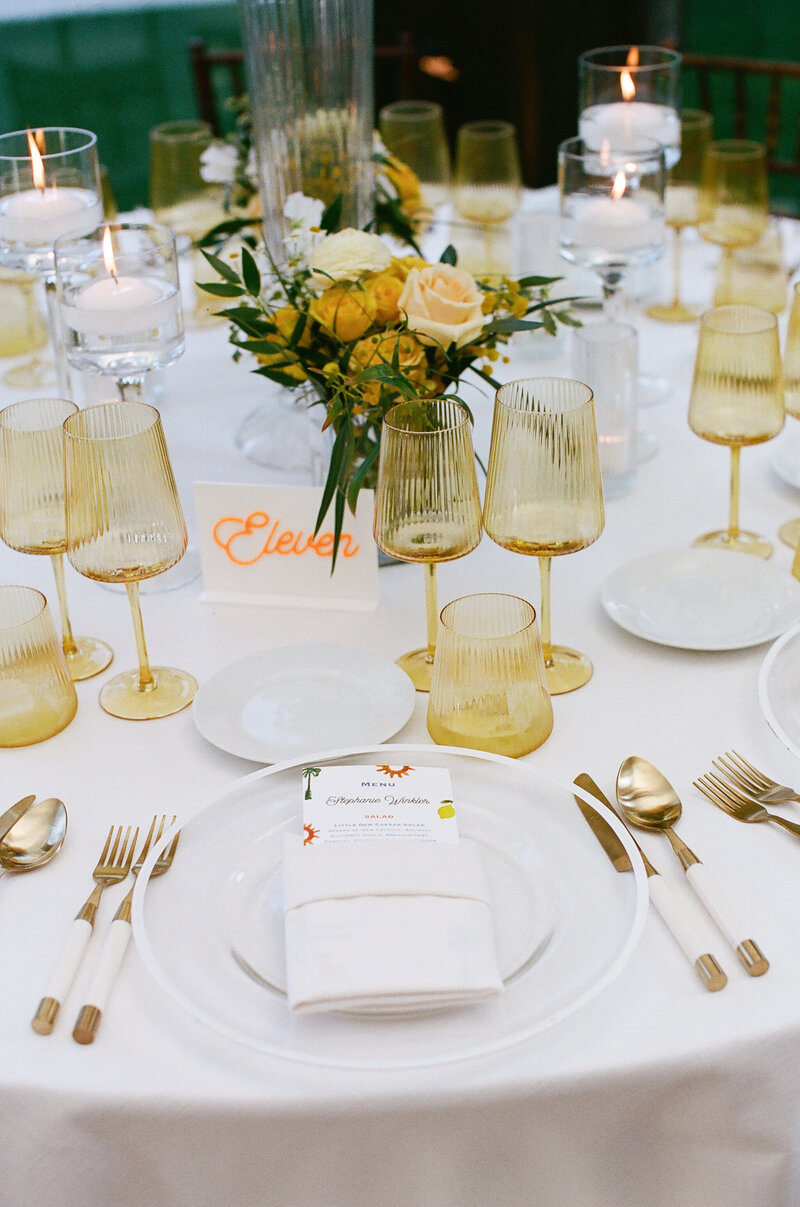 Formal wedding reception table with watercolor artwork menus and acrylic table numbers