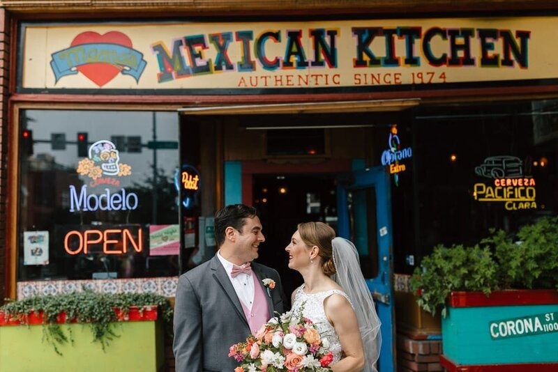 Couple standing in front of a cafe in downtown Seattle on their wedding day.