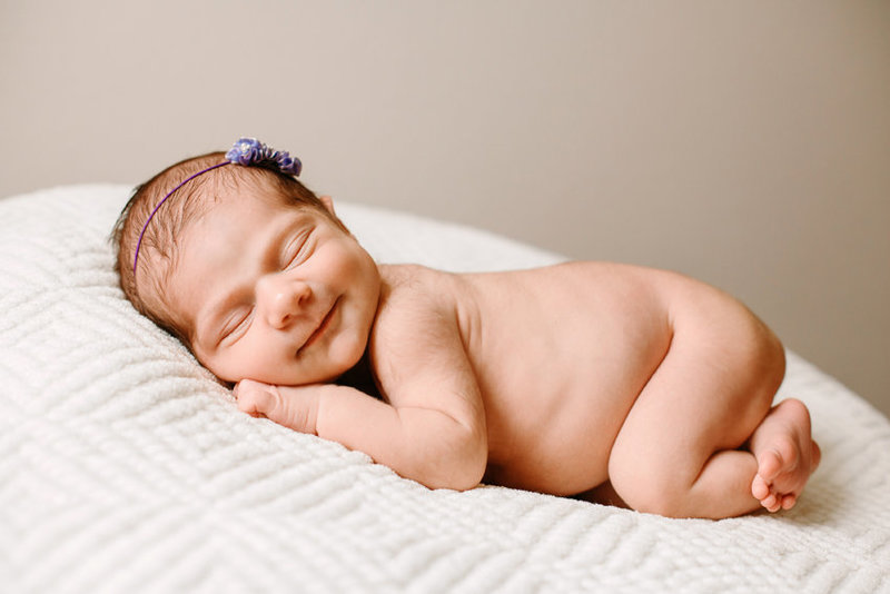 newborn baby smiling during her newborn session