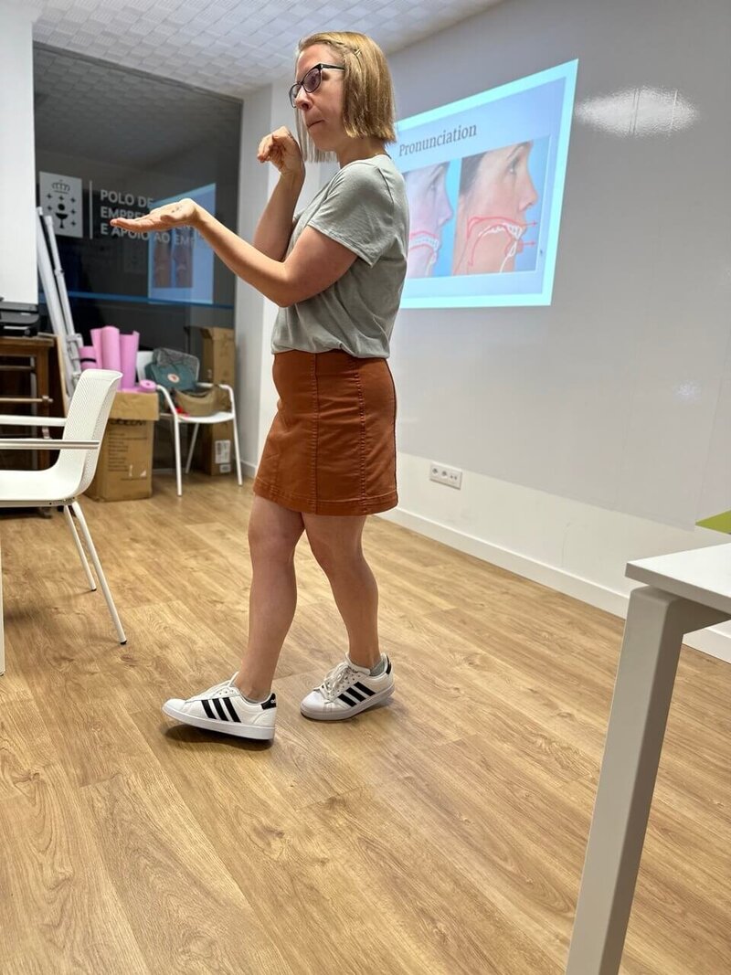 Stephanie uses her hands to demonstrate how air moves through the mouth when making a certain sound.