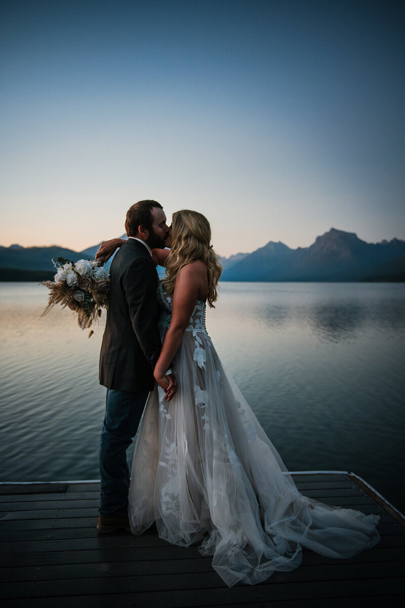 A happy bride and groom kiss on the shores of Flathead Lake in western Montana.