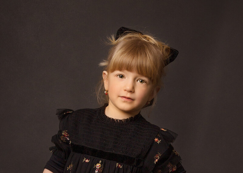 Little girl looks intently at the camera for a studio portrait.  Captured by premier Brooklyn NY family photographer Chaya Bornstein Photography.