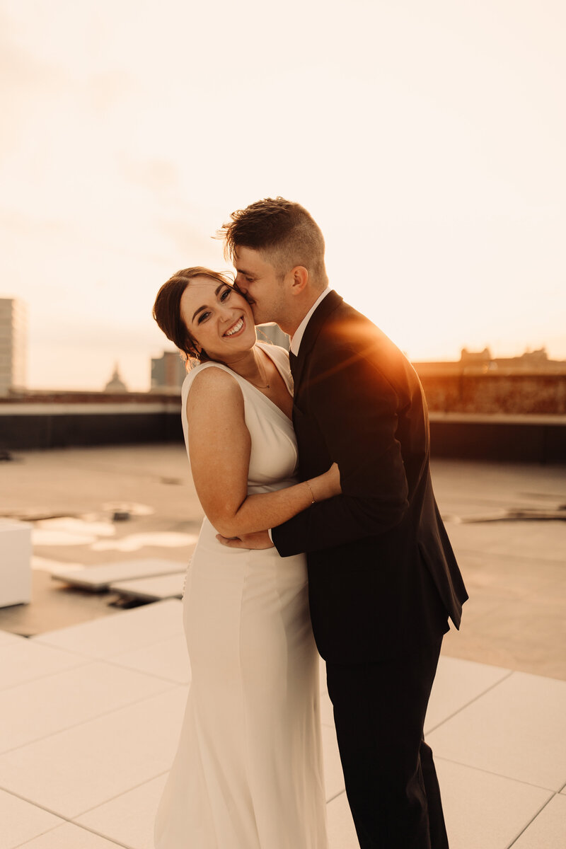 bride and groom on a rooftop at sunset in iowa