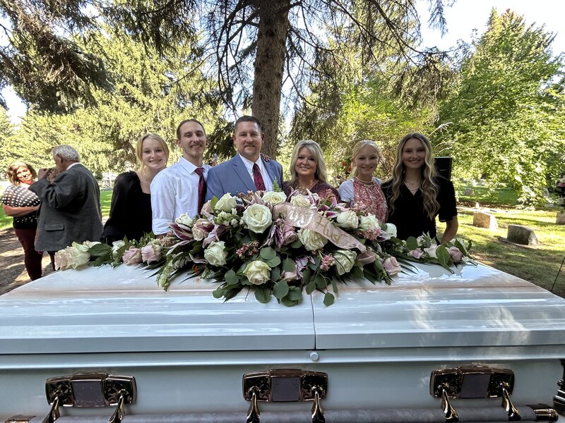 bride with her bridesmaids holding light pink rose bouquets outside the Logan LDS temple