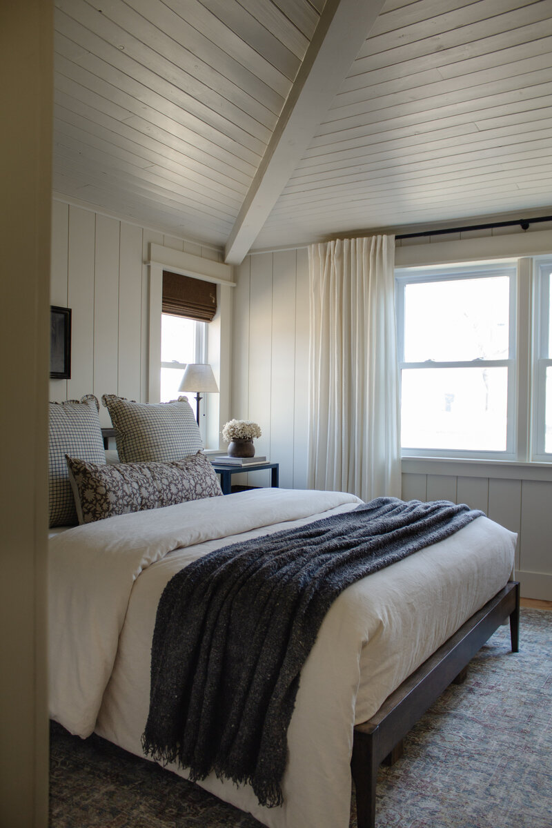 Primary bedroom renovation by Nadine Stay. Vertical  wood plank walls and wood plank ceiling. Low bedroom ceiling before and after.