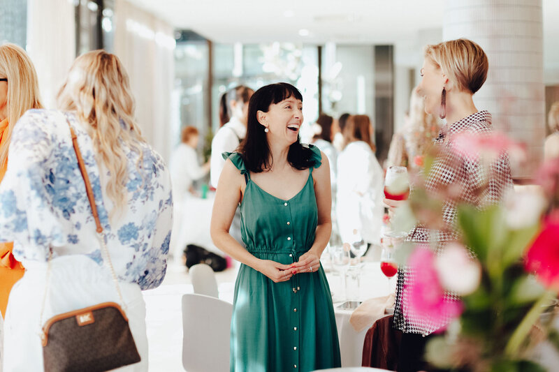 Two business women laughing whilst attending Emily Osmond's women's networking event.