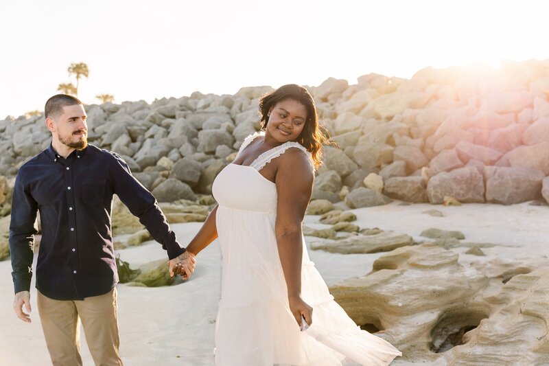 Couple holding hands walking on the beach together