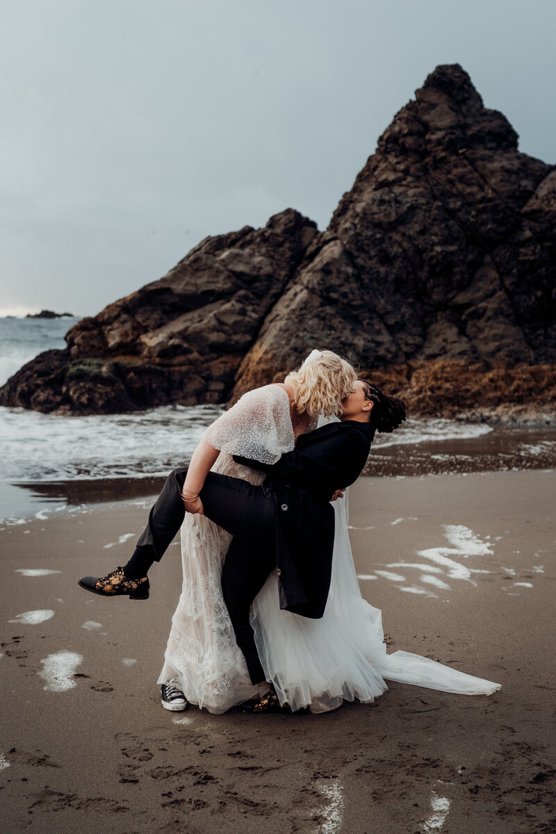 two brides kiss at beach elopement