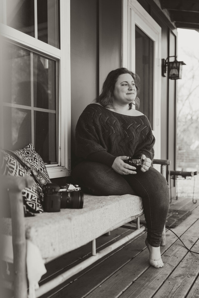 photographer holding film camera on front porch