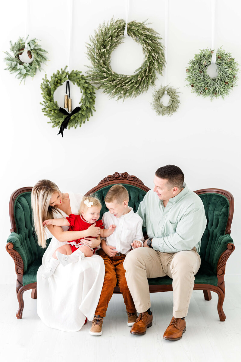 Family sitting on a couch together posing for mini model rep program