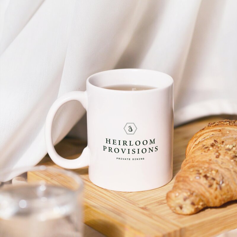A closeup of a personalized mug with a Heirloom Provisions logo