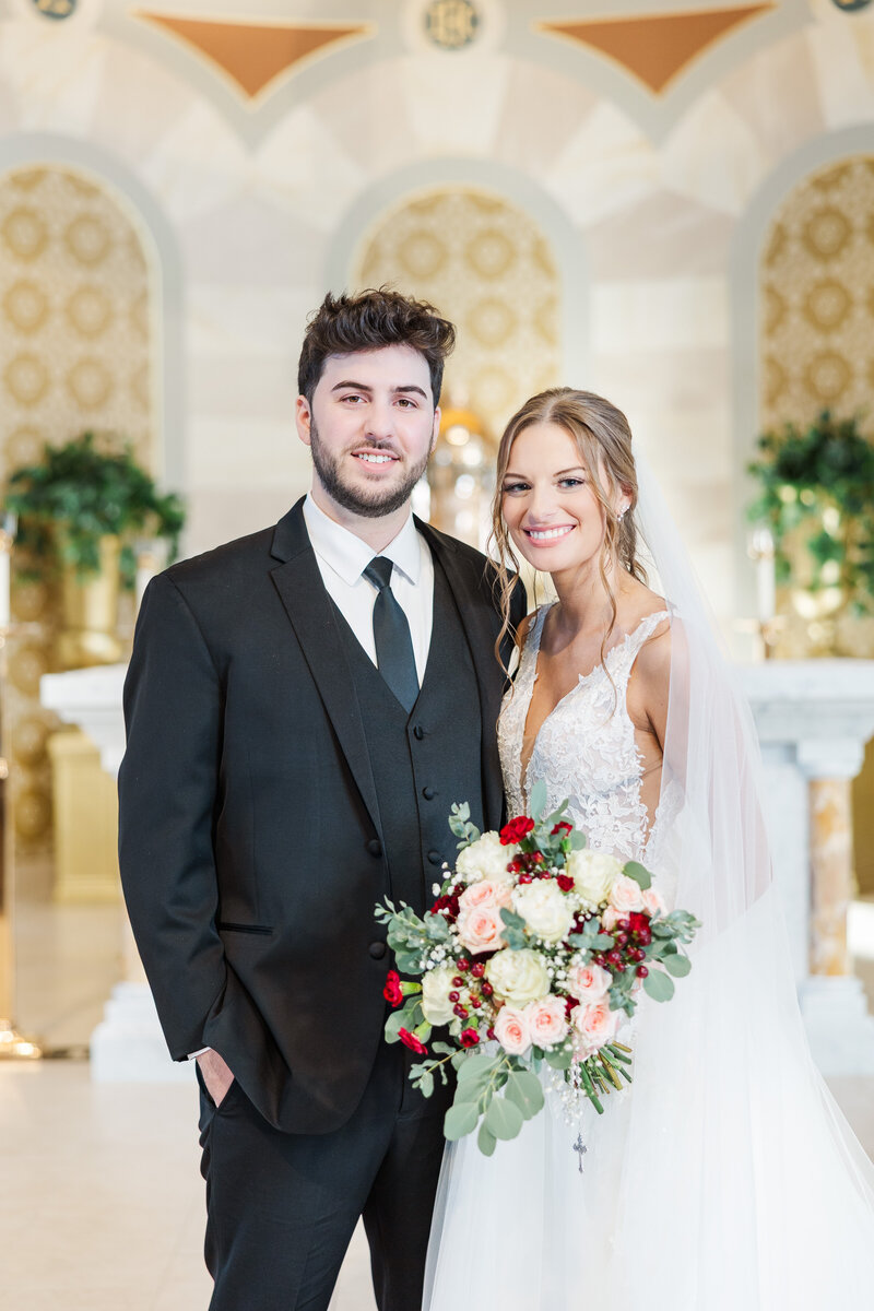 bride and groom smiling in a Catholic church sanctuary