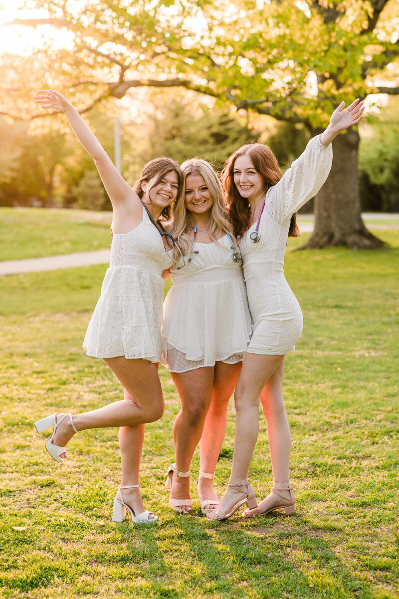 college graduate girls hug and cheer at sunset