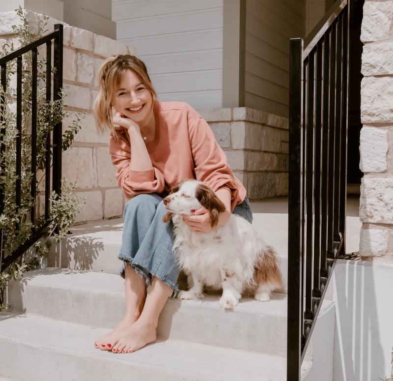 Ali and her dog sitting on steps smiling at camera